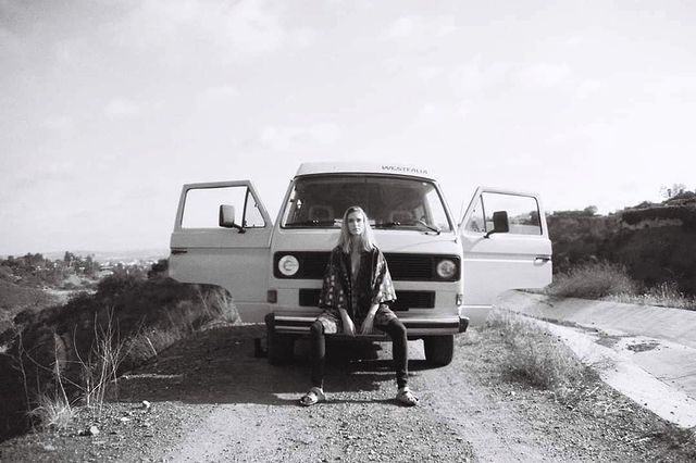 Black and white photo of Gaia Weiss in front of her vehicle.